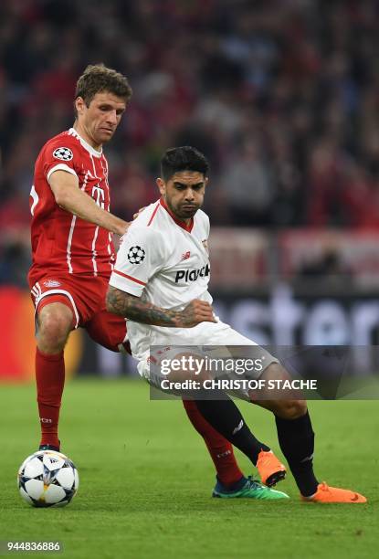 Bayern Munich's German forward Thomas Mueller and Sevilla's Argentinian midfielder Ever Banega vie for the ball during the UEFA Champions League...