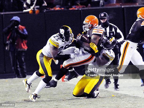 Running back Chris Jennings of the Cleveland Browns is tackled by defensive back Ryan Clark and linebacker Lawrence Timmons of the Pittsburgh...