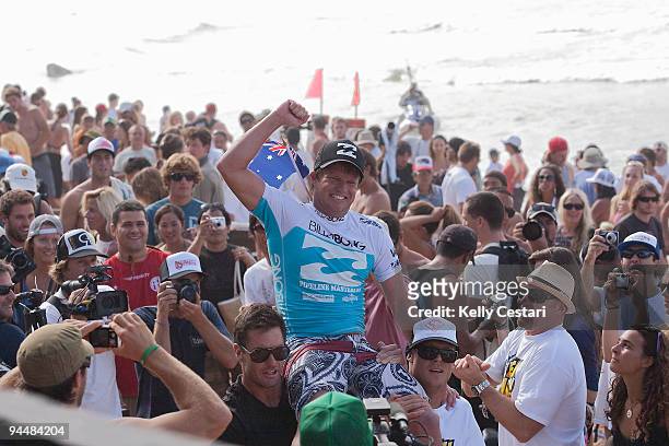 Taj Burrow is chaired up the beach by his coach Johnny Gannon and current 2X ASP World Champion Mick Fanning, all of Australia, after defeating Kelly...