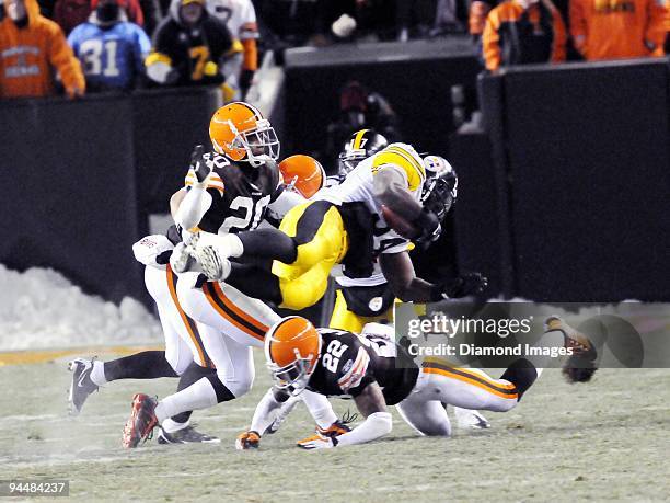 Running back Rashard Mendenhall of the Pittsburgh Steelers is tackled by defensive backs Brandon McDonald and Mike Adams of the Cleveland Browns...