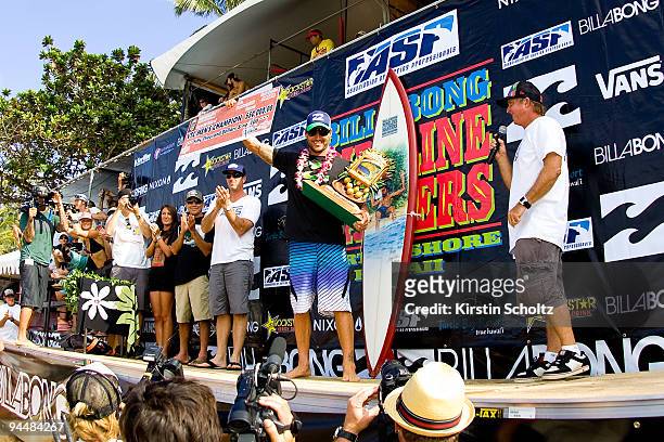 Joel Parkinson of Australia holds up his trophies after winning the Vans Triple Crown of Surfing at the Billabong Pipeline Masters on December 15,...