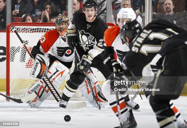 Jordan Staal of the Pittsburgh Penguins takes a shot in font of Matt Cooke and Brian Boucher of the Philadelphia Flyers on December 15, 2009 at...