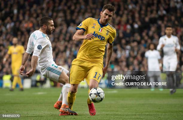 Real Madrid's Spanish defender Dani Carvajal vies with Juventus' Croatian forward Mario Mandzukic during the UEFA Champions League quarter-final...