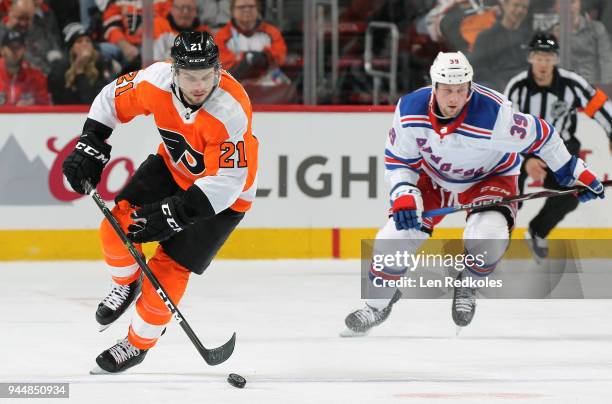 Scott Laughton of the Philadelphia Flyers skates the puck against Matt Beleskey of the New York Rangers on April 7, 2018 at the Wells Fargo Center in...