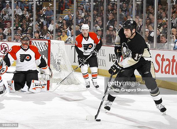 Mike Rupp of the Pittsburgh Penguins controls the puck in front of Brian Boucher and Claude Giroux of the Philadelphia Flyers on December 15, 2009 at...