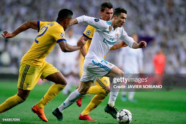 Juventus' Croatian forward Mario Mandzukic and Juventus' Brazilian defender Alex Sandro vie with Real Madrid's Portuguese forward Cristiano Ronaldo...