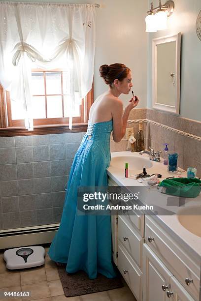 teenage girl in prom dress putting on lipstick. - prom dress stock pictures, royalty-free photos & images