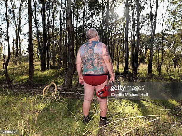 tattooed man with chainsaw - motorsåg bildbanksfoton och bilder