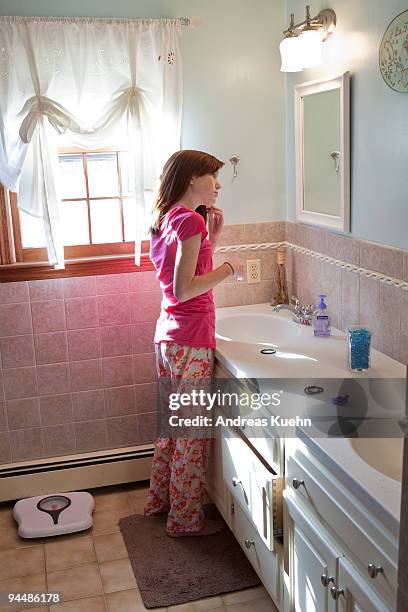 young teenage girl looking in bathroom mirror. - andreas kuehn bildbanksfoton och bilder