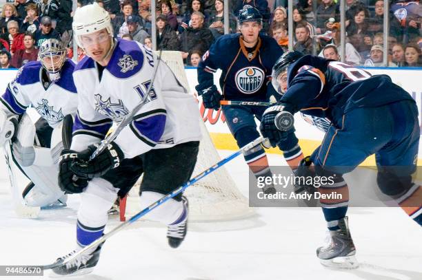 Brad Richardson of the Los Angeles Kings watches the flying puck while being covered by Gilbert Brule of the Edmonton Oilers at Rexall Place on...