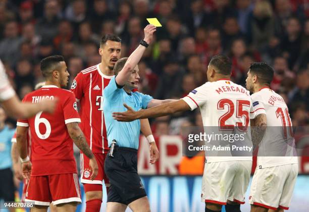 Referee William Collum shows Ever Banega of Sevilla a yellow card during the UEFA Champions League Quarter Final Second Leg match between Bayern...