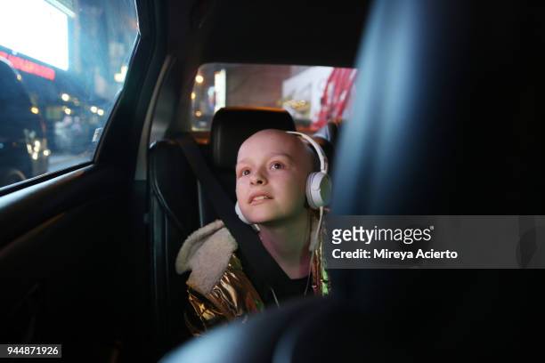 a young girl with cancer, riding in a car, looks at all the bright lights of the city. - motorheadphones stock pictures, royalty-free photos & images