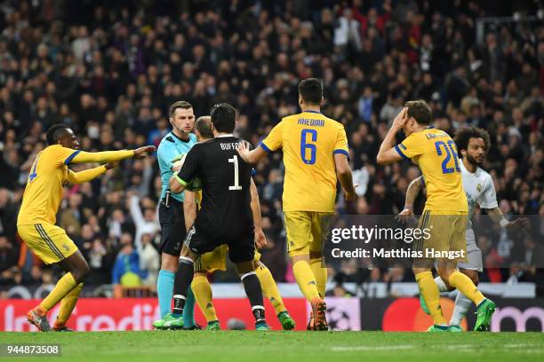 Gianluigi Buffon of Juventus confronts referee Michael Oliver after he awards Real Madrid a penalty during the UEFA Champions League Quarter Final...