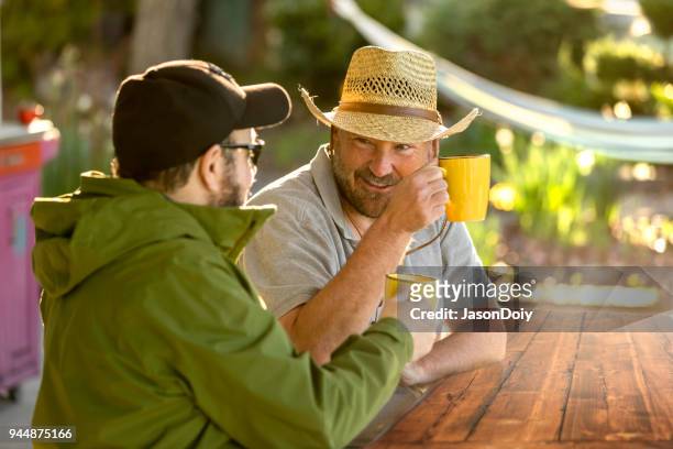 gelukkig lachend mid volwassene man drinken koffie - jasondoiy stockfoto's en -beelden
