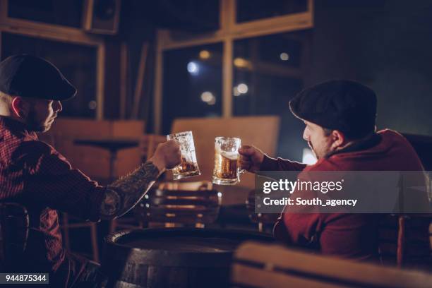 two friends in pub drinking beer - bar atmosphere stock pictures, royalty-free photos & images