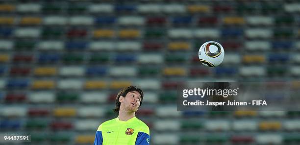 Lionel Messi of FC Barcelona eyes the ball during a training session at the Zayed Sports City stadium on December 15, 2009 in Abu Dhabi, United Arab...