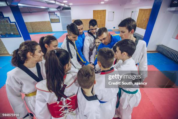taekwondo team holding hands - karate belt stock pictures, royalty-free photos & images