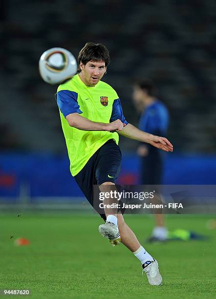 Lionel Messi of FC Barcelona strikes the ball during a training session at the Zayed Sports City stadium on December 15, 2009 in Abu Dhabi, United...