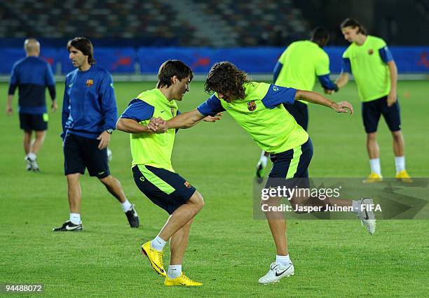 Bojan Krkic excrecises with Carles Puyol of FC Barcelona during a training session at the Zayed Sports City stadium on December 15, 2009 in Abu...