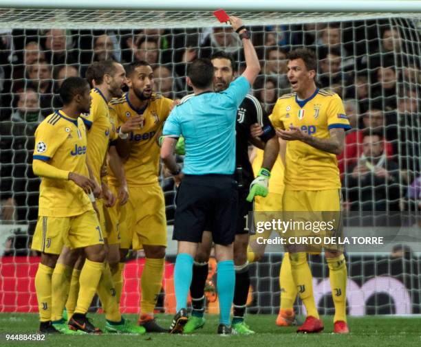 English referee Michael Oliver shows a read card to Juventus' Italian goalkeeper Gianluigi Buffon during the UEFA Champions League quarter-final...