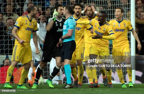 Juventus players protest to English referee Michael Oliver during the UEFA Champions League quarter-final second leg football match between Real...