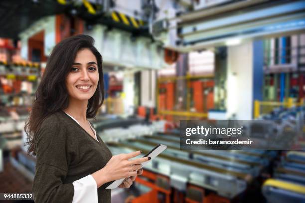 young female engineer holding digital tablet to operate automation - the evolution of the female gaze stock pictures, royalty-free photos & images