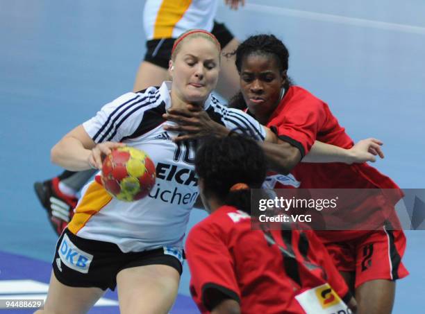 Anna Loerper of Germany is blocked by Angola players during the main round match between Angola and Germany at Yangzhou Stadium on day eleven of the...