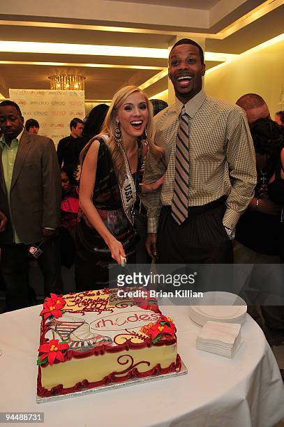 Miss USA Kristen Dalton and NY Jets safety Kerry Rhodes cut the cake during the holiday shopping mixer at the Jimmy Choo store in the Short Hills...