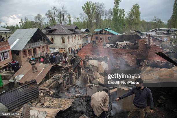 Kashmiri civilians search the debris of three house after a gunfight between rebels and government forces Wednesday, April 11 in Khudwani village...