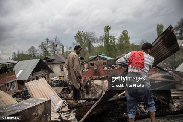 Kashmiri civilians search the debris of a house after a gunfight between rebels and government forces Wednesday, April 11 in Khudwani village about...