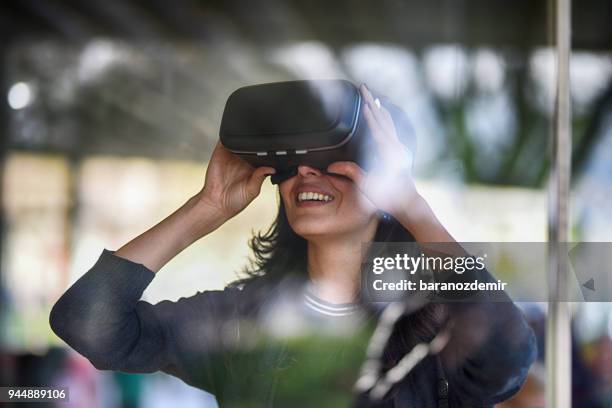 jonge vrouw op zoek met vr achter het glas - virtual reality stockfoto's en -beelden