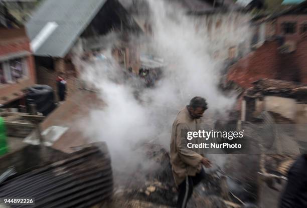 Kashmiri man searches the debris of a house after a gunfight between rebels and government forces Wednesday, April 11 in Khudwani village about 60...