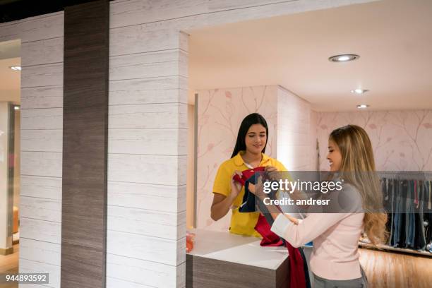 frau versucht kleidung an der garderobe in einem geschäft - künstlergarderobe stock-fotos und bilder