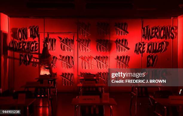 Jenni Boelkens adds tally marks to a wall in the Parkland 17 exhibition at the Standard Hotel in Los Angeles, California on April 11 to total 96 for...