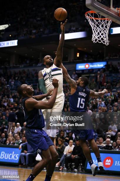 Brandon Jennings of the Milwaukee Bucks attempts a shot while being guarded by Bismack Biyombo and Rodney Purvis of the Orlando Magic in the second...