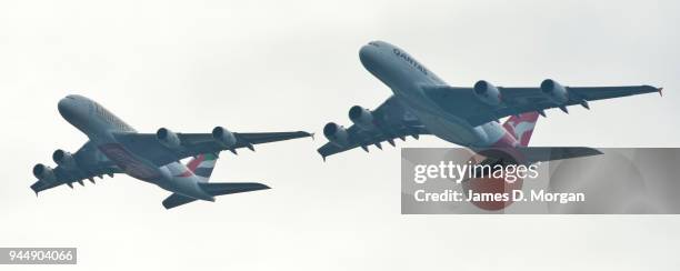 Two Airbus A380's belonging to Qantas and Emirates fly over the top of the Opera House on March 31, 2013 in Sydney, Australia. A Qantas A380 and an...