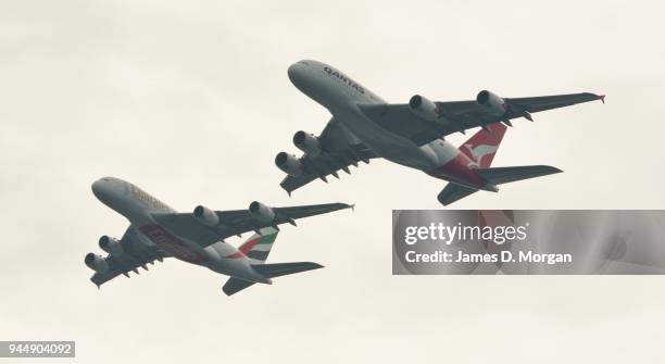 Two Airbus A380's belonging to Qantas and Emirates fly over the top of the Opera House on March 31, 2013 in Sydney, Australia. A Qantas A380 and an...