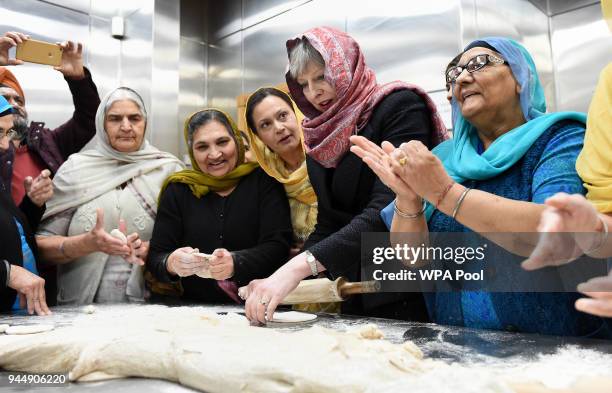 British Prime Minister Theresa May helps with food preparation during her visit to the Guru Nanak Sikh Gurdwara to mark Vaisakhi on April 11, 2018 in...