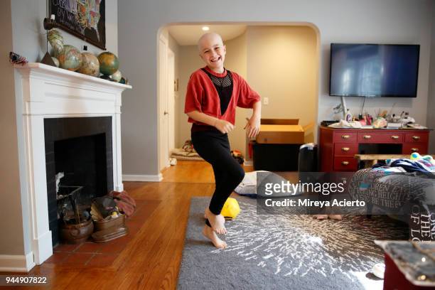 a young girl with cancer, dancing in a living room, with a big smile. - cancer illness stock pictures, royalty-free photos & images