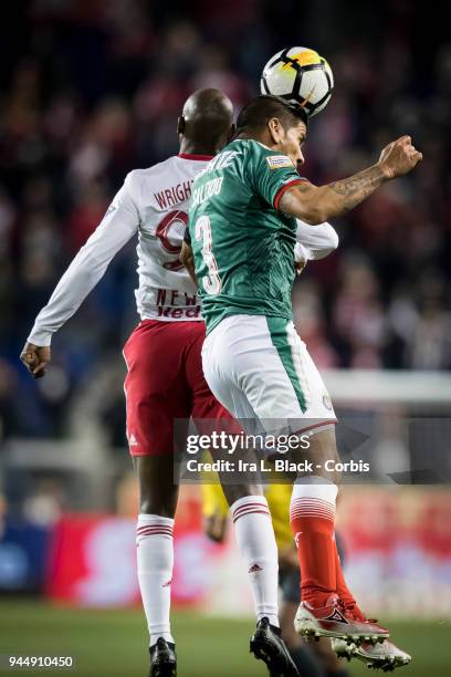 Captain Carlos Salcido of Guadalajara goes up for the header against Bradley Wright-Phillips of New York Red Bulls during the CONCACAF Champions...