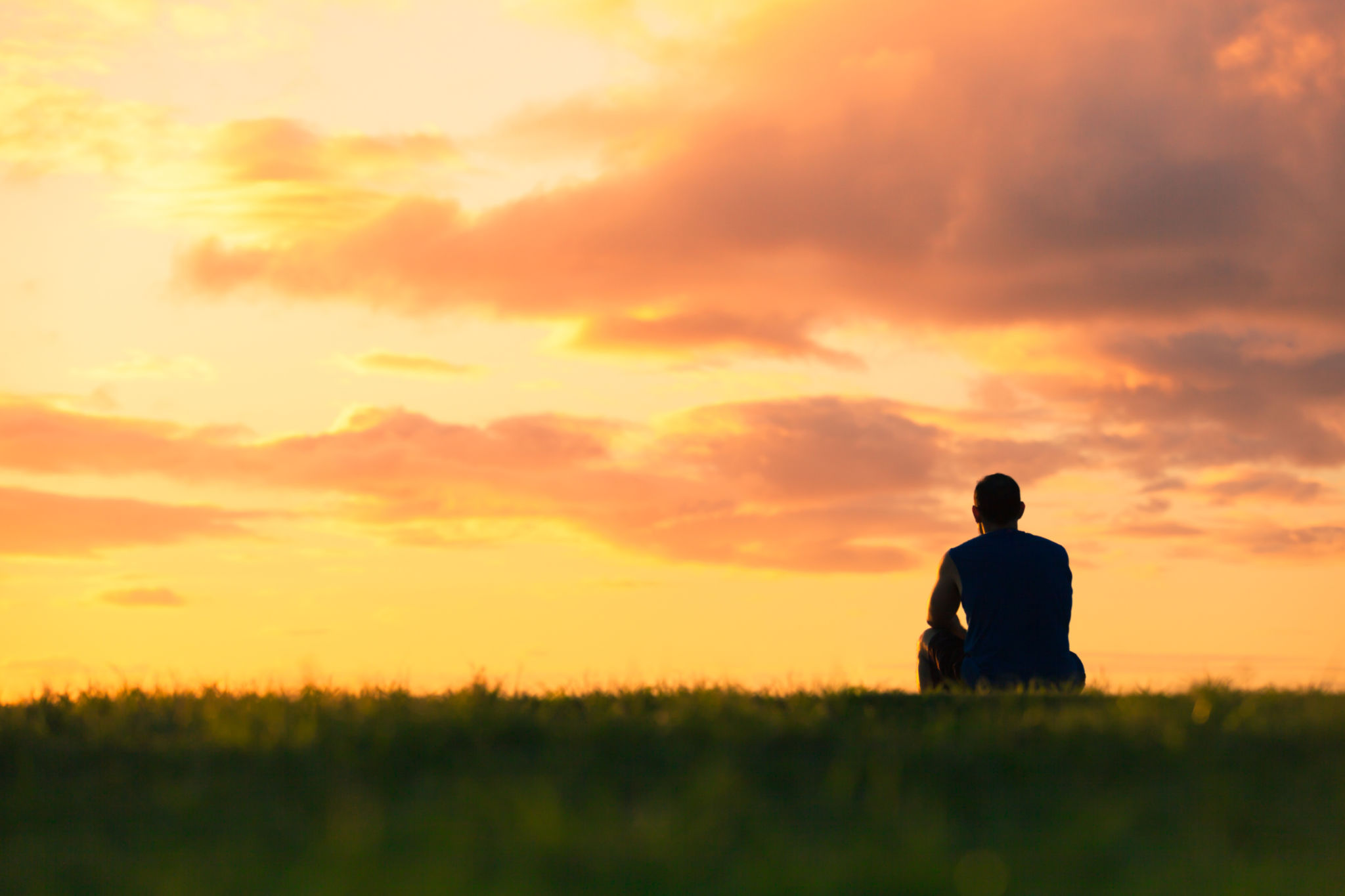 Man sitting watching sunset Man sitting watching sunset