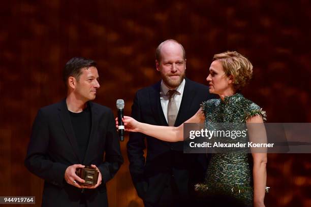 Winners of the 'Best Web-Project' Award Daniel Mueller, Holger Starck and host Caren Miosga speak on stage at the Nannen Award 2018 at...