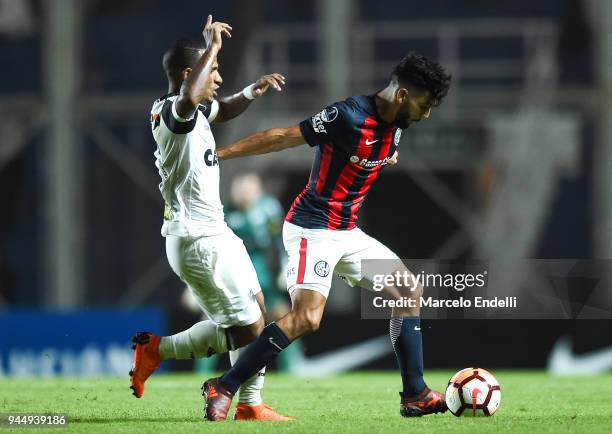 Gabriel Gudino of San Lorenzo fights for the ball with Romulo Otero of Atletico Mineiro during a match between San Lorenzo and Atletico Mineiro as...