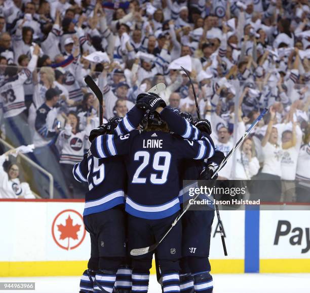 Jets players celebrate a goal by Mark Scheifele of the Winnipeg Jets celebrate Scheifele's goal against the Minnesota Wild in Game One of the Western...