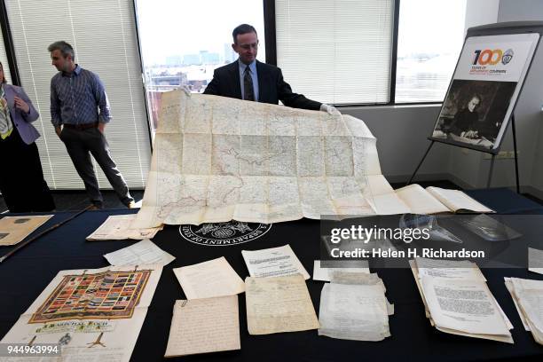 Robin Peaslee Dougall, looks at a map inside an original copy of the Treaty of Versailles that belonged to his grandfather U.S. Army Major Amos J....