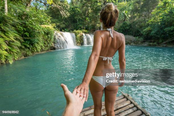 folgen sie mir in konzept junge frau führenden freund zum idyllischen wasserfall - behind waterfall stock-fotos und bilder