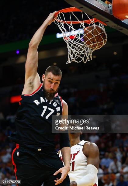 Jonas Valanciunas of the Toronto Raptors dunks the ball over Hassan Whiteside of the Miami Heat during the first half at American Airlines Arena on...