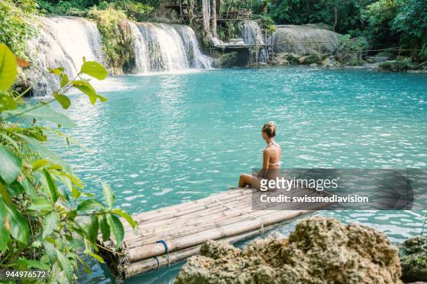 ragazza che contempla una bellissima cascata nelle filippine da zattera di bambù - bamboo raft foto e immagini stock