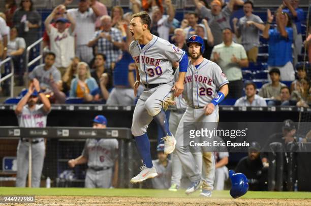 Michael Conforto of the New York Mets jumps in the air after scoring the go ahead run in the eighth inning against the Miami Marlins at Marlins Park...