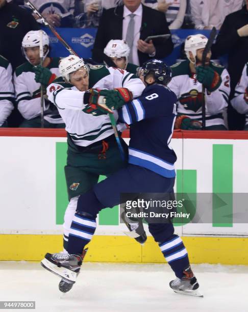 Jacob Trouba of the Winnipeg Jets collides with Nino Niederreiter of the Minnesota Wild during first period action in Game One of the Western...